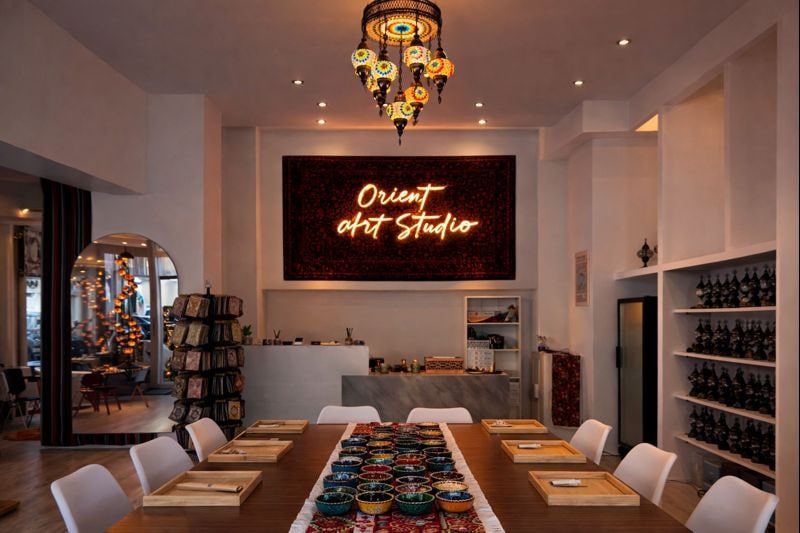 Innenraum des Orient Art Studio in Berlin mit großem Workshop-Tisch und orientalischen Mosaiklampen