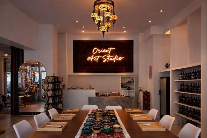 Innenraum des Orient Art Studio in Berlin mit großem Workshop-Tisch und orientalischen Mosaiklampen