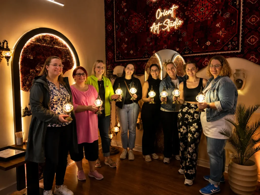 Frauengruppe präsentiert selbst gestaltete orientalische Mosaiklampen im Orient Art Studio Berlin nach einem kreativen Workshop.